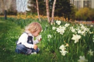 Young girl smelling flower - nature connectedness