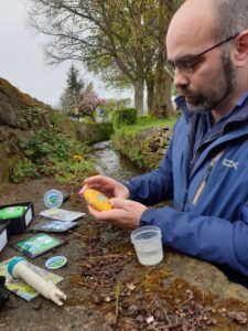 Sam using water testing kit at riverside