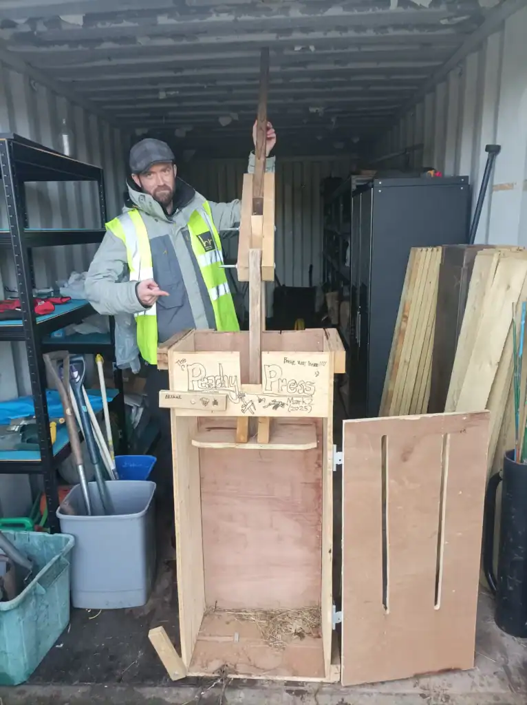 Man working on wooden structure for fruit pressing