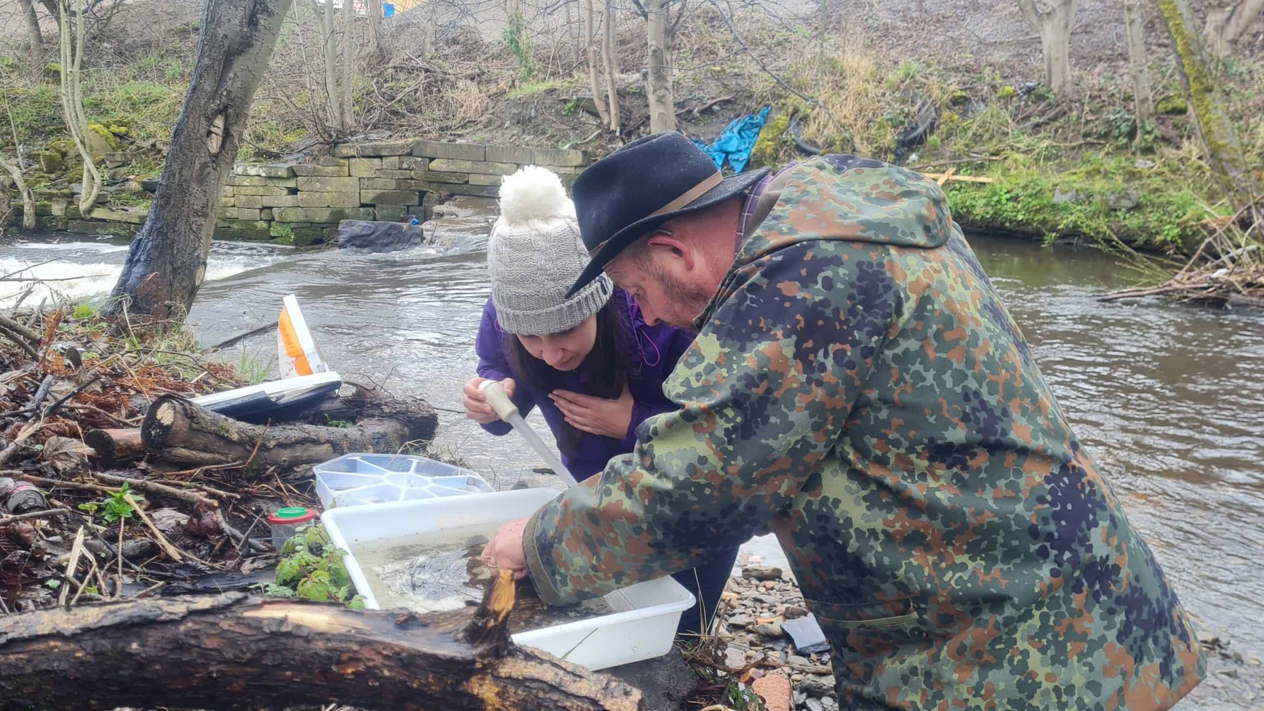 Two people poring over a Riverfly sample