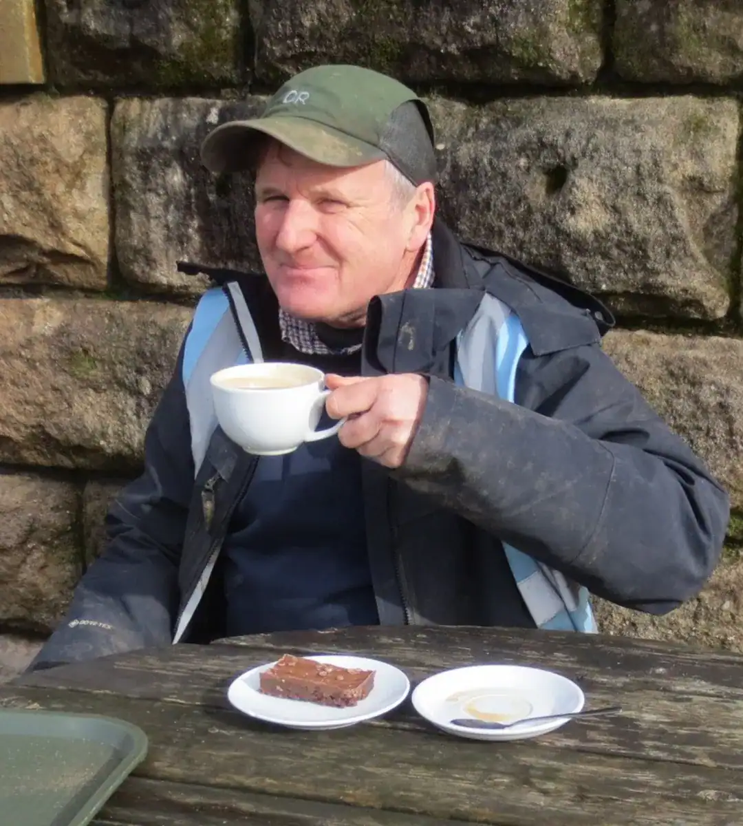 Half-shot of Nick Milson eating biscuits and drinking tea