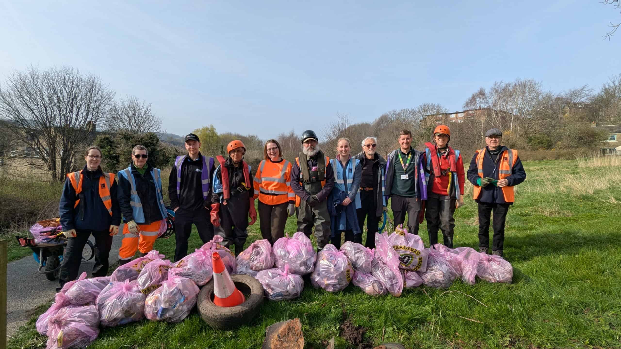 A group of littl piker volunteers with many bags of litter they have collected
